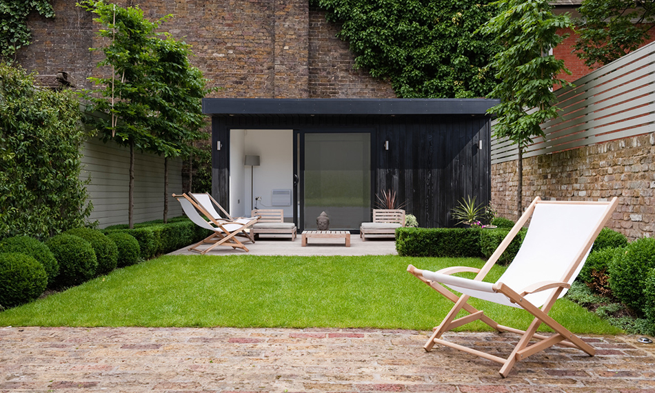 Deck chair on brick patio in Kensington garden